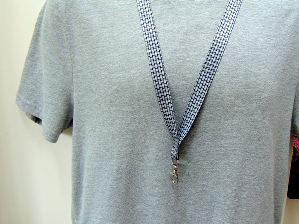 20mm silver grey lanyard with a printed weave effect pattern. Worn on a grey T shirt.